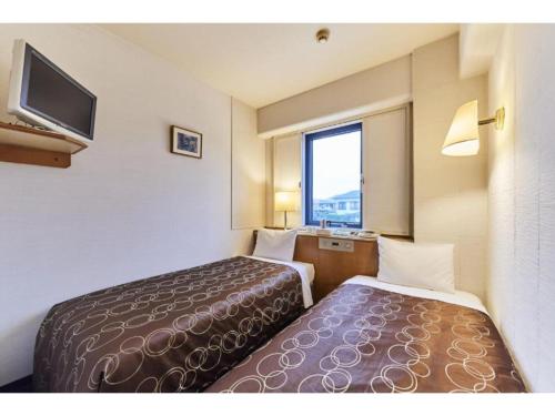 a hotel room with two beds and a television at Urayasu Sun Hotel - Vacation STAY 33015v in Urayasu