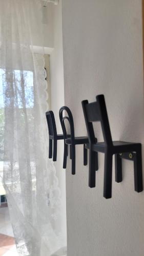 two black chairs on a wall next to a window at Domus Olea in Policastro Bussentino