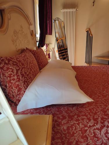 a bed with a large white pillow on it at Casa Aurora in Ravenna