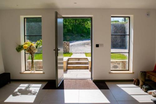 a room with a door with a view of a yard at Woodmill Arches - Designer Barn Conversion for Two in Lindores