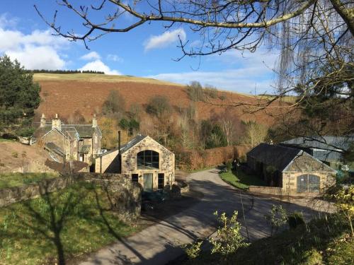 a large house in the middle of a field at Woodmill Arches - Designer Barn Conversion for Two in Lindores