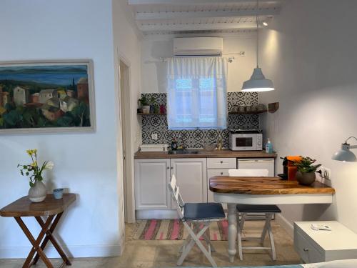 a small kitchen with a table and a table and chairs at La Casa Del Barbiere in Argyrádes