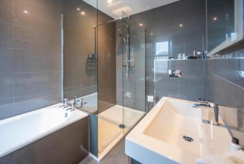 a bathroom with a shower and a sink and a tub at Heathmount Hotel in Inverness