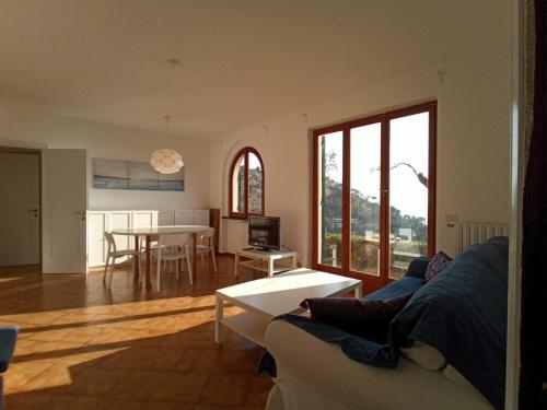een woonkamer met een bank en een tafel bij VILLA ROSA CON SPLENDIDA VISTA MARE in Bonassola