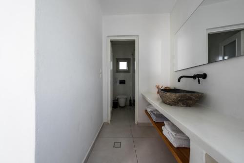 a bathroom with a counter with a sink and a toilet at Smaro Studios in Firostefani