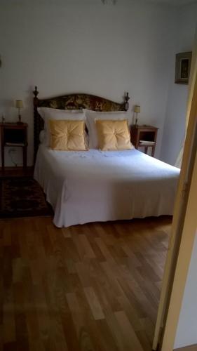 Bett mit weißer Bettwäsche und Kissen in einem Zimmer in der Unterkunft L'Hirondelle in Saint-Jacut-les-Pins