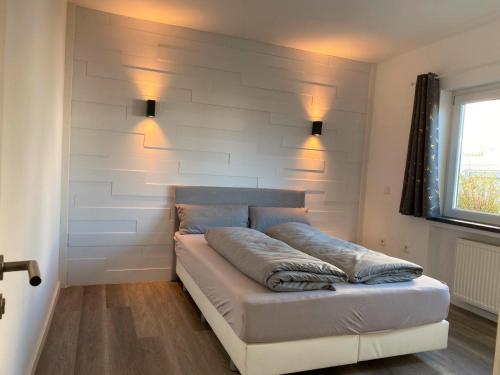 a bed in a room with a wall with lights at Schöne Lemgoer Unterkunft in Lemgo