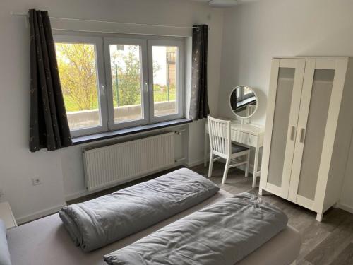 uma cama num quarto com uma secretária e uma janela em Schöne Lemgoer Unterkunft em Lemgo