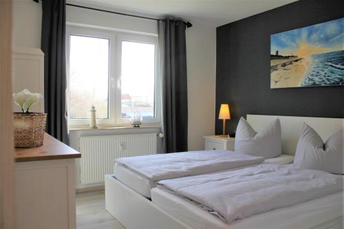 1 dormitorio con cama blanca y ventana en Brandt, en Kirchdorf