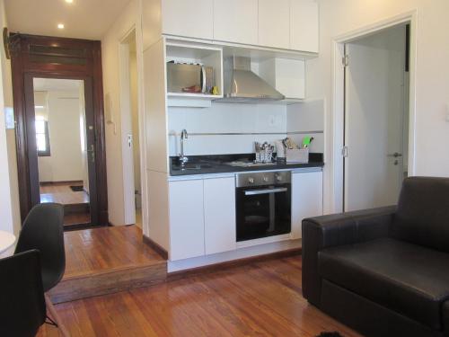 a kitchen with a stove and a couch in a room at Apartamentos en el palacio salvo in Montevideo