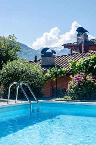 a swimming pool in front of a house at AnMa Cottages The Secret Garden in Pianello Del Lario