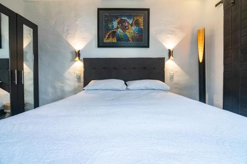 a bedroom with a large white bed with two lights at The first real Bed & Breakfast Hiking Hotel 'The Office' in Arequipa, Peru in Arequipa