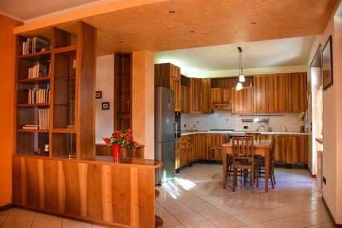 a kitchen with wooden cabinets and a table with chairs at Casa Rosetta in Pescantina