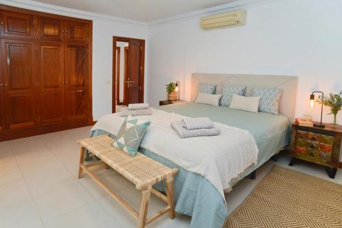 1 dormitorio con 1 cama grande y armario de madera en Luxury Buenavista el Charco + private parking, en Arrecife