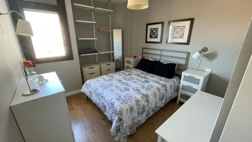 1 dormitorio con 1 cama y 2 mesas blancas en Apartamento en Playa del Ingles CC Yumbo en Maspalomas