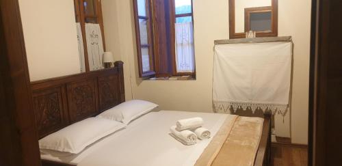 a bedroom with a bed with two towels on it at Silver Hill Guesthouse in Gjirokastër
