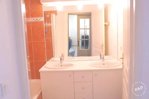 a bathroom with two sinks and a mirror at Superbe appartement T2 de 50m2 près de Genève à Saint Julien en Genevois idéal pour couple avec 2 enfants jusqu'à 18 ans in Saint-Julien-en-Genevois