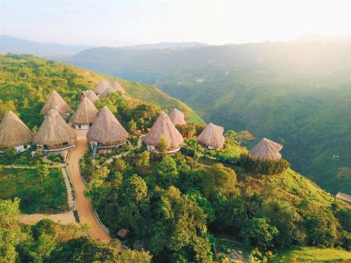 an aerial view of a group of huts on a hill at Ceiba by Masaya Collection in San Agustín