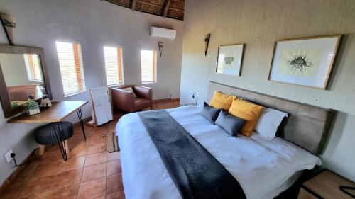 a bedroom with a large bed in a room with windows at Boabab Lodge in Mabula