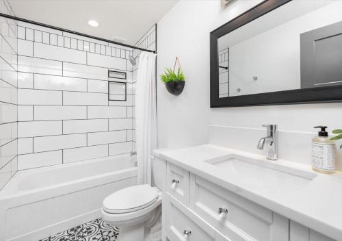 a white bathroom with a sink and a tub and a toilet at Mid Century Modern Boise-River Bungalow w/ Hot Tub in Boise