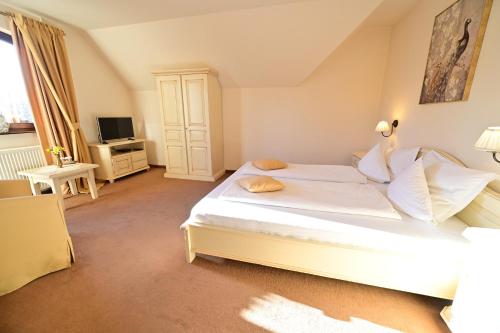 a bedroom with a white bed and a television at Natura Family Resort in Avrig