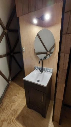 a bathroom with a sink and a mirror at Glamping Domo Pullao in Castro