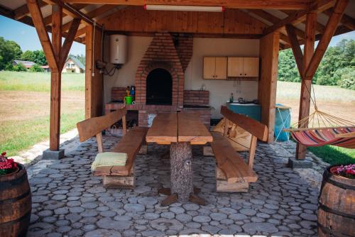 a patio with a wooden table and a kitchen at Na Piaskach Domek nad rzeką Agroturystyka in Narol