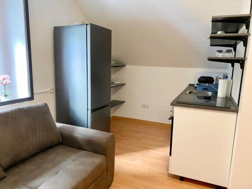 a kitchen with a stainless steel refrigerator and a couch at Apartments Lissy I und II in Neunkirchen