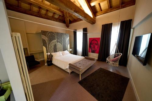 a bedroom with a bed and some windows at Ginevra Boutique Rooms - Palazzo Leosini - Residenze D'Epoca in LʼAquila