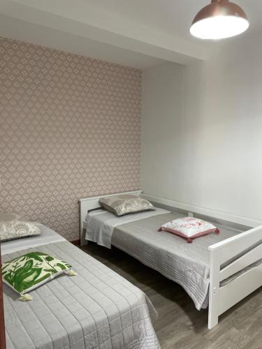 une chambre avec deux lits et une lampe dans l'établissement Cosy au coeur des 3 vallées, à Argelès-Gazost