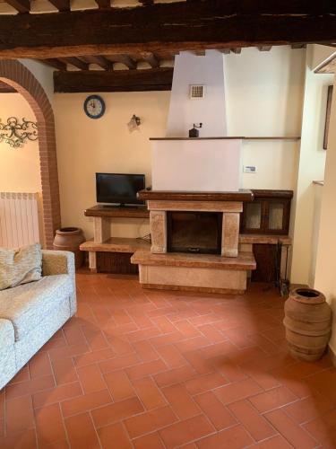 a living room with a couch and a fireplace at Casetta Campiglia d'Orcia in Campiglia dʼOrcia