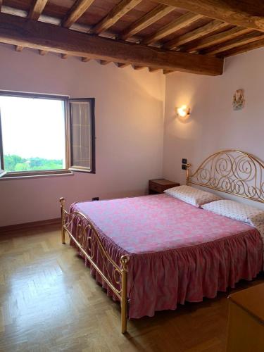een slaapkamer met een bed en een groot raam bij Casetta Campiglia d'Orcia in Campiglia dʼOrcia