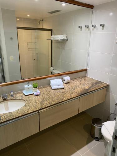y baño con lavabo y espejo. en Apart Hotel em Ondina en Salvador