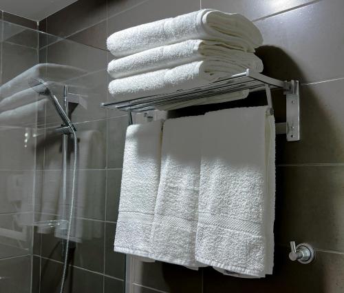 a bunch of towels on a towel rack in a bathroom at Beit Alshabaan Inn in Wadi Musa