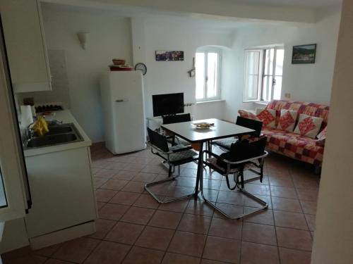 a kitchen and living room with a table and chairs at La Terrazza nel carrùggio in Fezzano