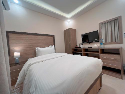 a bedroom with a bed and a desk and a television at Beit Alshabaan Inn in Wadi Musa