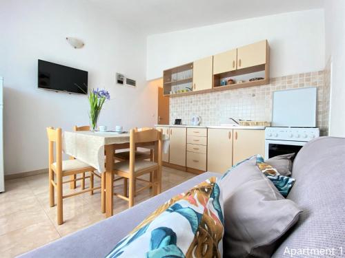 sala de estar con sofá, mesa y cocina en Apartments Bosotina en Kukljica