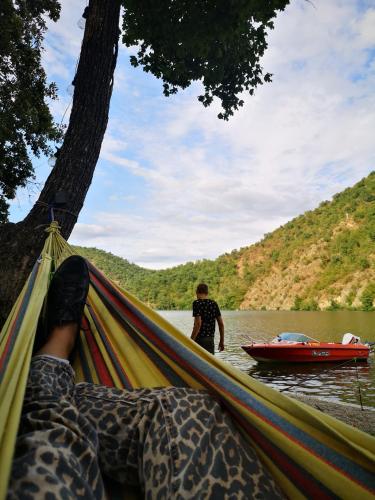 a person laying in a hammock next to a boat at Nautica Bahna in Orşova