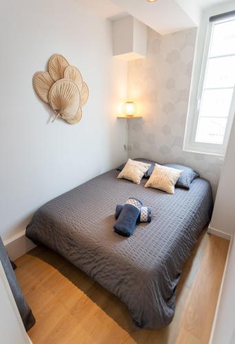un lit dans une chambre avec deux oreillers dessus dans l'établissement 4 pers centre-ville / 300M Plage, à Royan