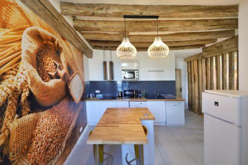 a kitchen with a wooden table in a room at LE BAS CHITRAY in Ménil