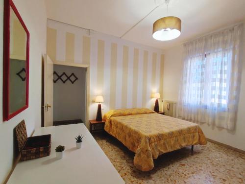 a bedroom with a bed and two tables and a window at Lovely Balcony San Gimignano Apartments in San Gimignano