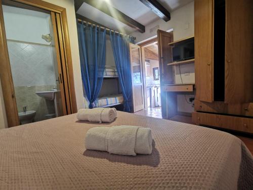 una camera da letto con un letto con due asciugamani sopra di Le Casette di Nino a Marina di Camerota