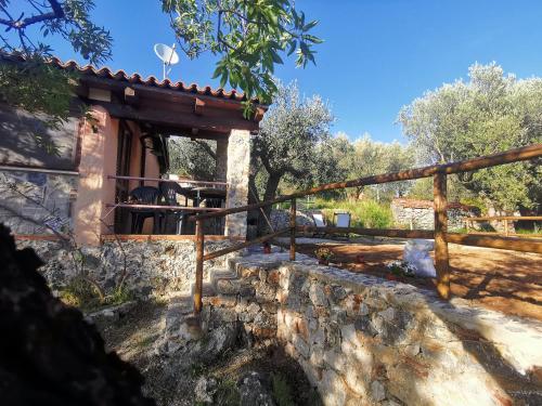 una casa con un muro in pietra e una recinzione in legno di Le Casette di Nino a Marina di Camerota