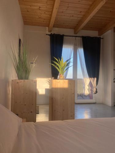a bedroom with a bed and a window with plants at Olea b&b in Montecosaro