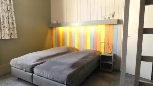 a bedroom with a bed with a colorful wall at Le Chaumont in Theux