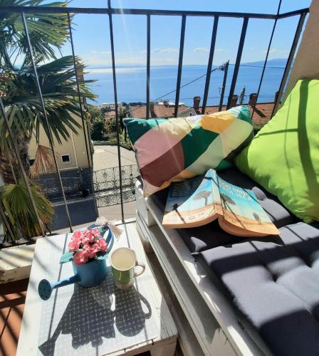 a balcony with a table and a view of the ocean at MORABEZA Opatija in Opatija
