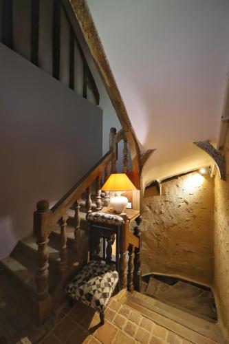 a stairway with a table with a lamp on it at LE BAS CHITRAY in Ménil