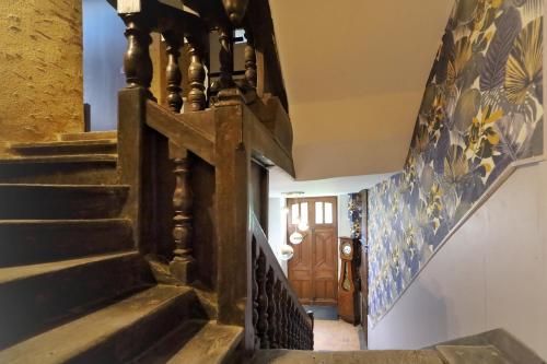 a hallway with stairs and a wooden door at LE BAS CHITRAY in Ménil