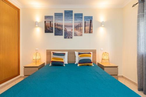 カバナス・デ・タビラにあるCasa do Afonso Cabanas Beachのベッドルーム1室(大型ブルーベッド1台、ランプ2つ付)
