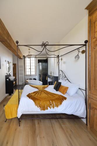 a bedroom with a large bed with white sheets and orange pillows at LE BAS CHITRAY in Ménil